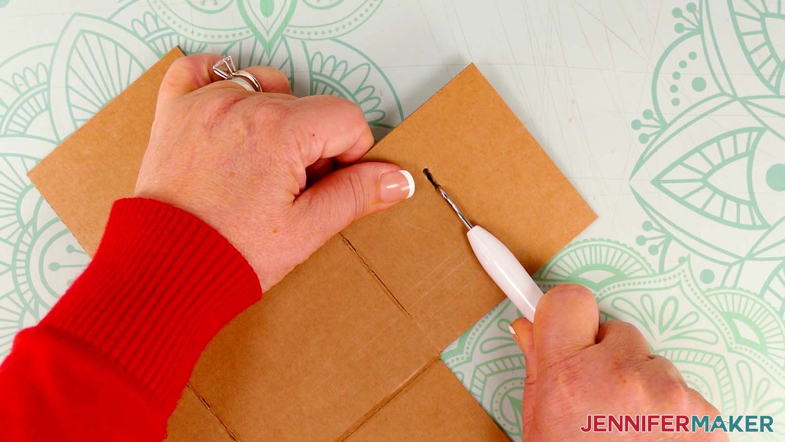 Use a weeding tool to finish making the small slits in the panels for the elastic pieces on the cardboard jumping box