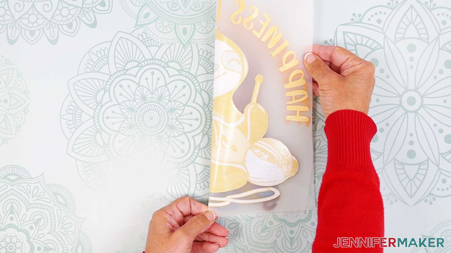 Crease the center of the carrier sheet film at the top and bottom of the Cricut DTF design.