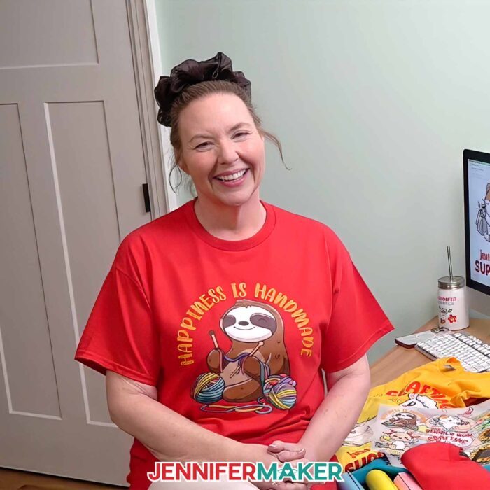 Jennifer Maker wears a T-shirt decorated with one the Cricut DTF Transfers she ordered from Cricut Design Space, featuring a cute crafting sloth design