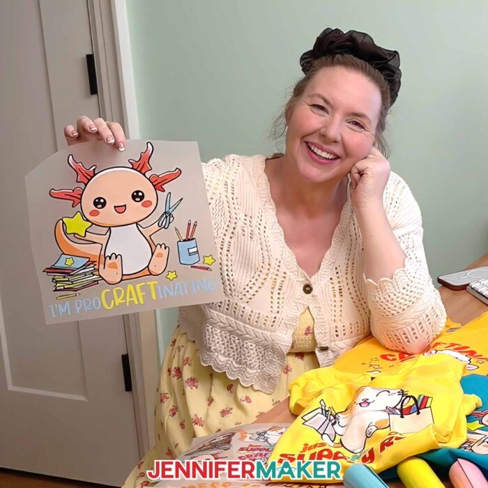 Jennifer Maker shows off one of the Cricut DTF Transfers she ordered from Cricut Design Space, featuring a cute crafting axolotyl design