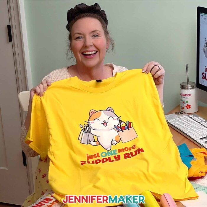 Jennifer Maker shows off one of the T-shirts decorated with Cricut DTF Transfers ordered through Cricut Design Space, featuring a cute crafty cat design