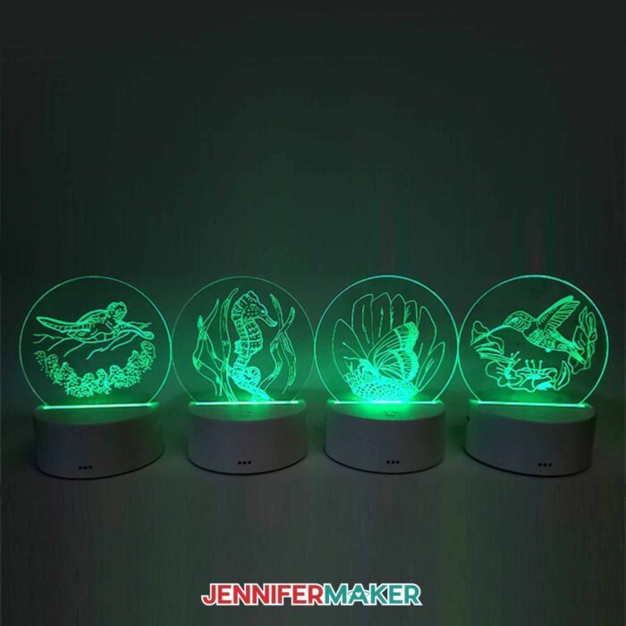 Four acrylic nightlights with green light illuminating them