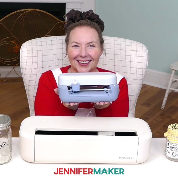 Jennifer Maker holding the Cricut Joy 2 above a Cricut Explore 5.
