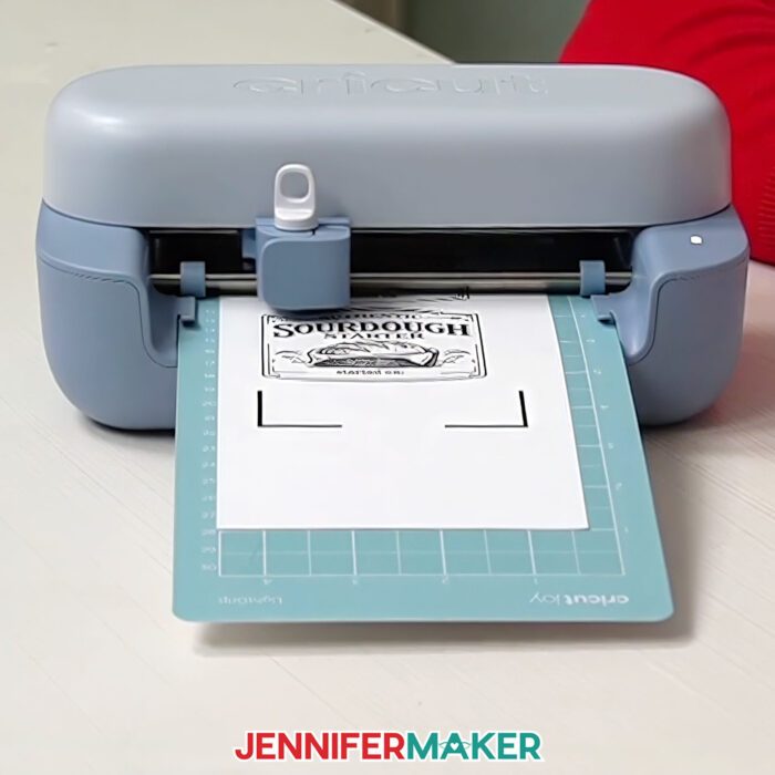 A Cricut Joy 2 making a Print Then Cut project on a blue machine mat.