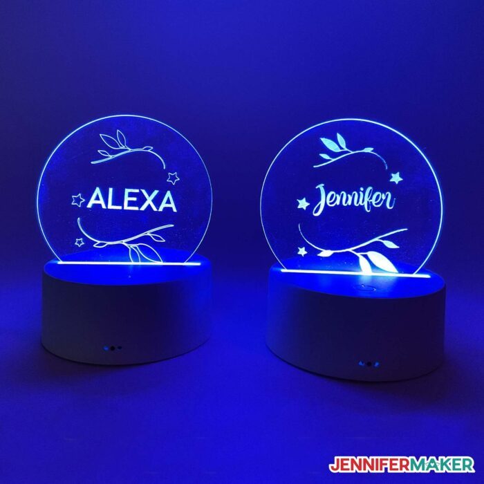 Acrylic nightlights engraved with filled in designs by a Cricut with the lights off.