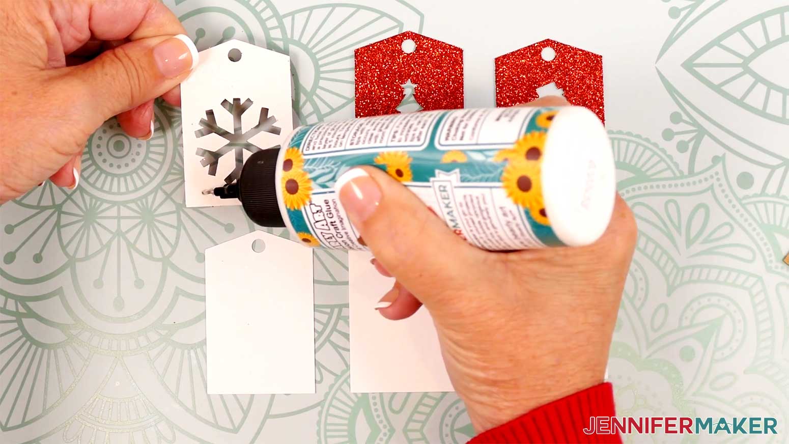 Add glue to the back of the tag-shaped glitter pieces before adhering them to the white tags in the Cricut Gift Wrapping Ideas project.