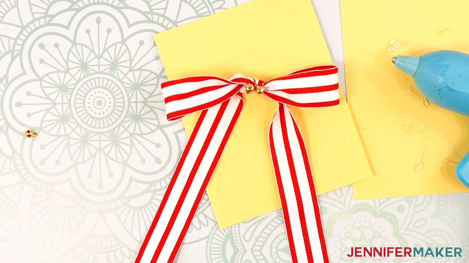 Adhere jingle bells with hot glue to the center of the ribbon bow for the Elf Boots Ribbon in the Cricut Gift Wrapping Ideas project.