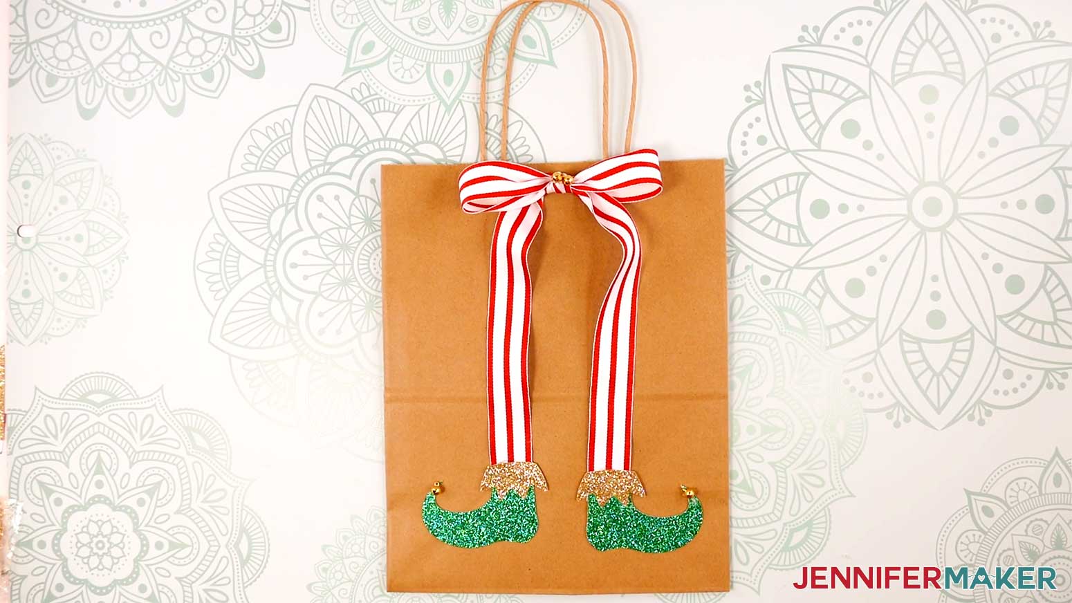 Adhere the Elf Boots Ribbon to a gift bag in the Cricut Gift Wrapping Ideas project.