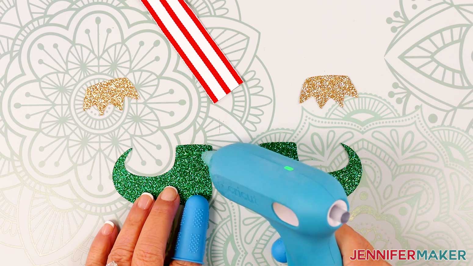 Apply hot glue to the top front of the boots pieces for the Elf Boots Ribbon in the Cricut Gift Wrapping Ideas project.