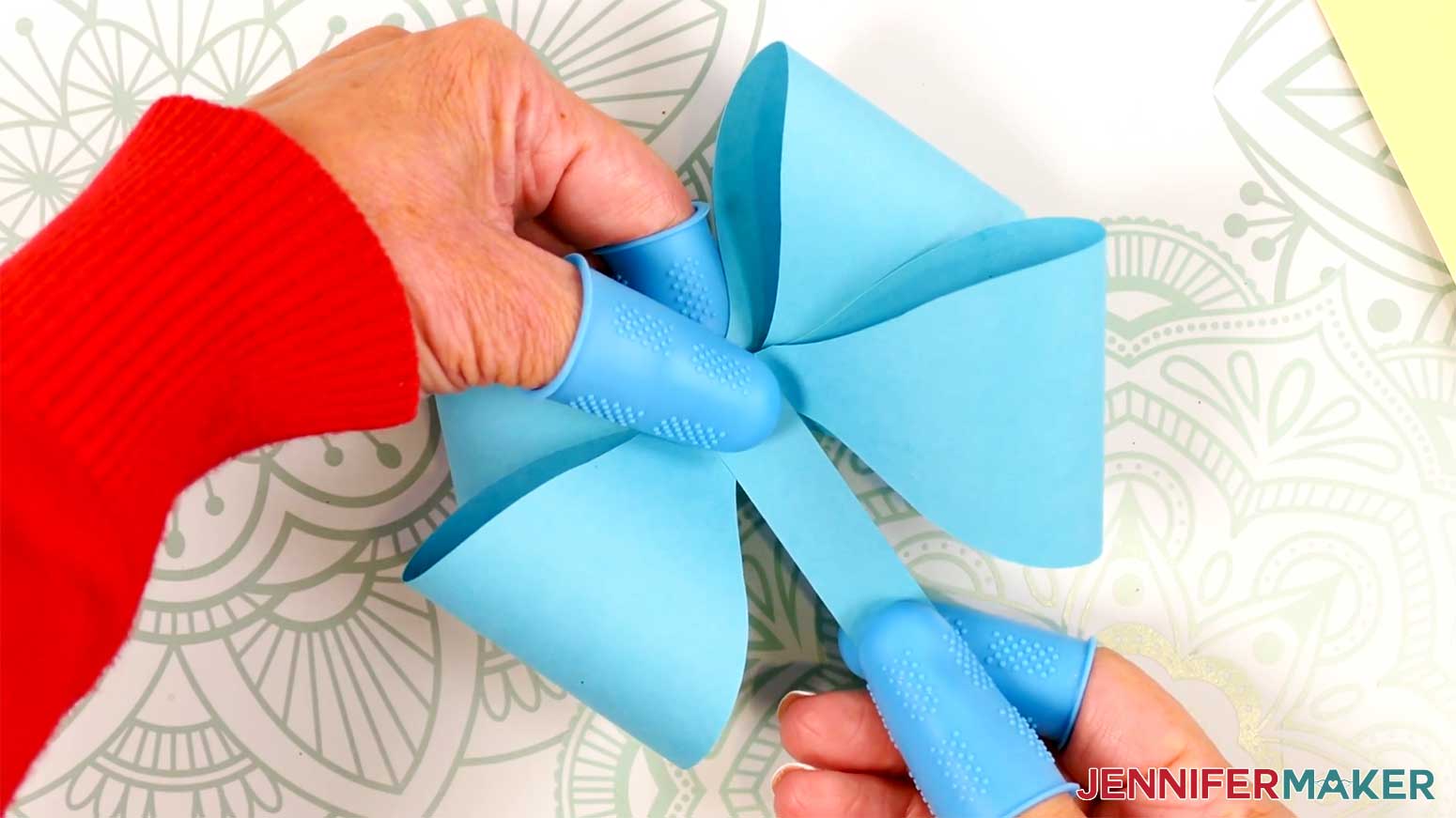 Adhere the long strip to the center of the Fancy Paper Bow using hot glue in the Cricut Gift Wrapping Ideas project.