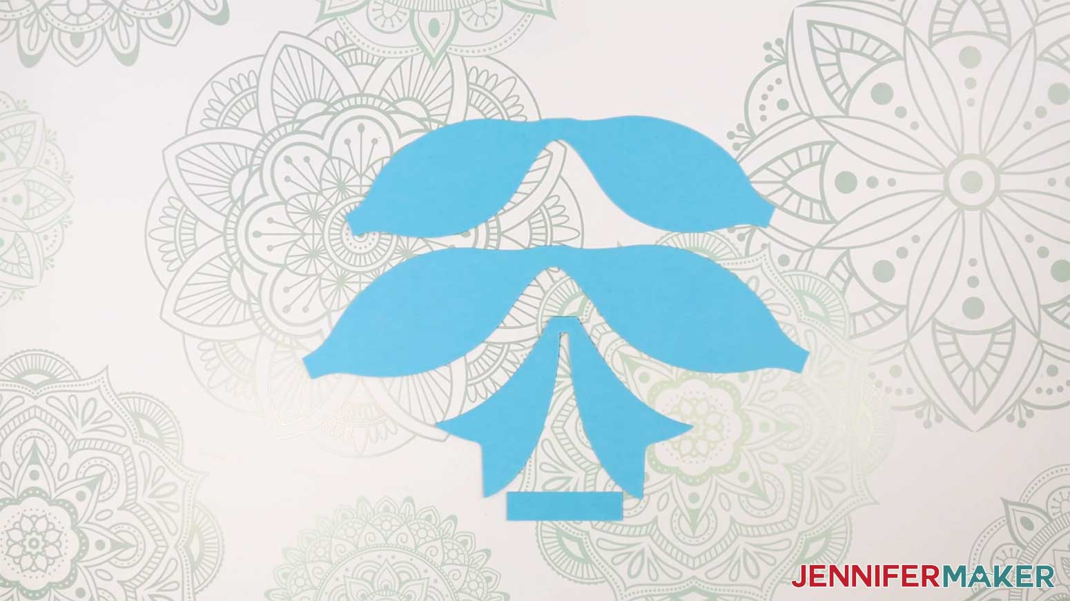 Cut pieces from the Fancy Paper Bow laid on the work surface in the Cricut Gift Wrapping Ideas project.
