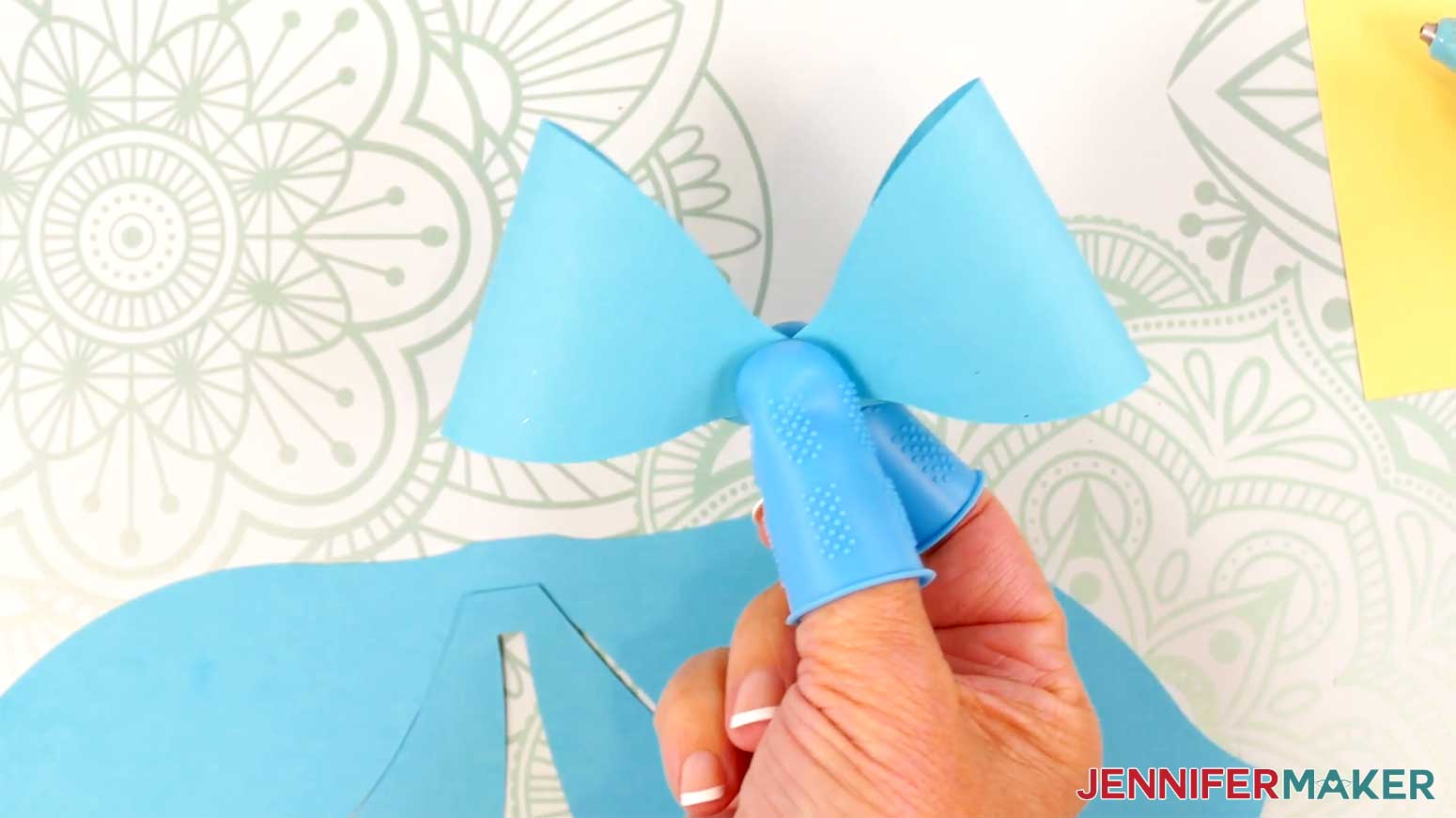 Fold the other side of the Fancy Paper Bow's top loop down into the hot glue in the Cricut Gift Wrapping Ideas project.