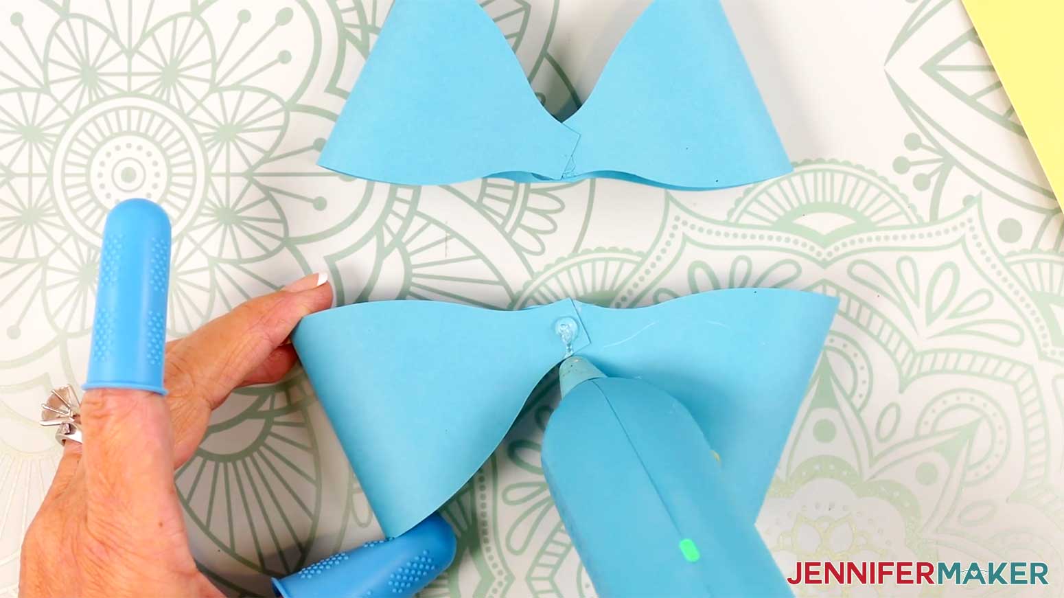 Apply hot glue to the center of the assembled bottom loops of the Fancy Paper Bow in the Cricut Gift Wrapping Ideas project.