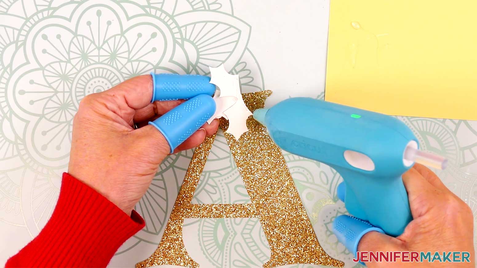 Apply a line of hot glue to the bottom back edge of the assembled holly piece.