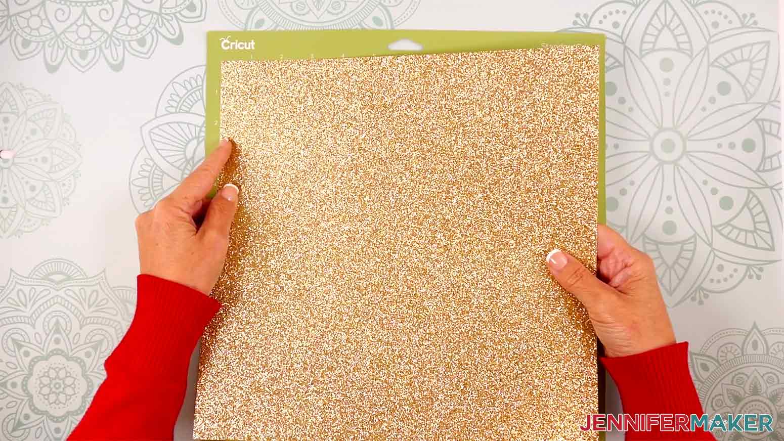 Place the gold glitter cardstock face up on a green machine mat.