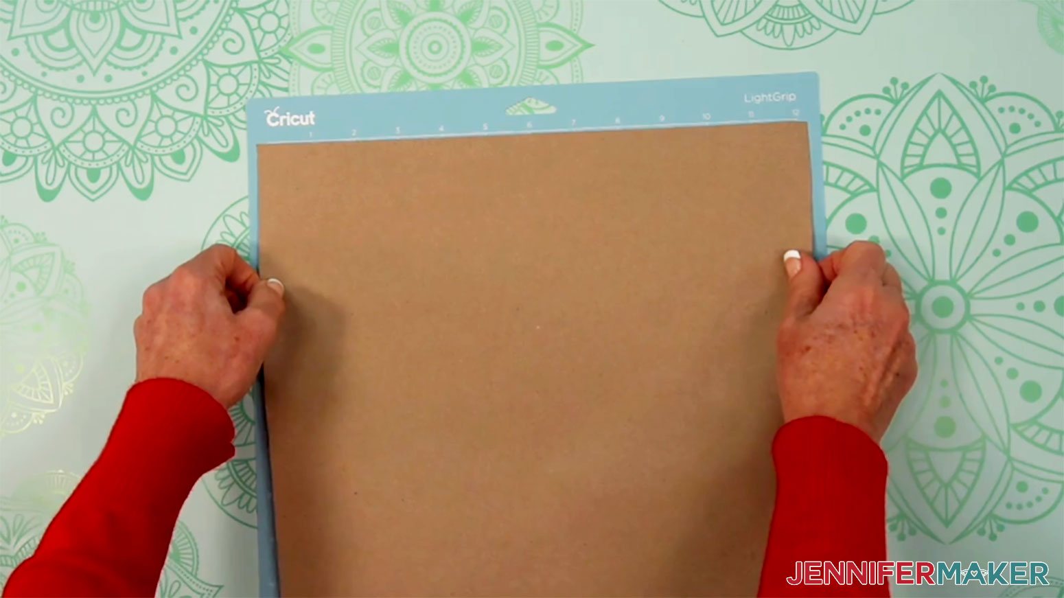 Adhere the kraft paper to a blue LightGrip machine mat for the Cricut Pen Gift Wrap in the Cricut Gift Wrapping Ideas project.