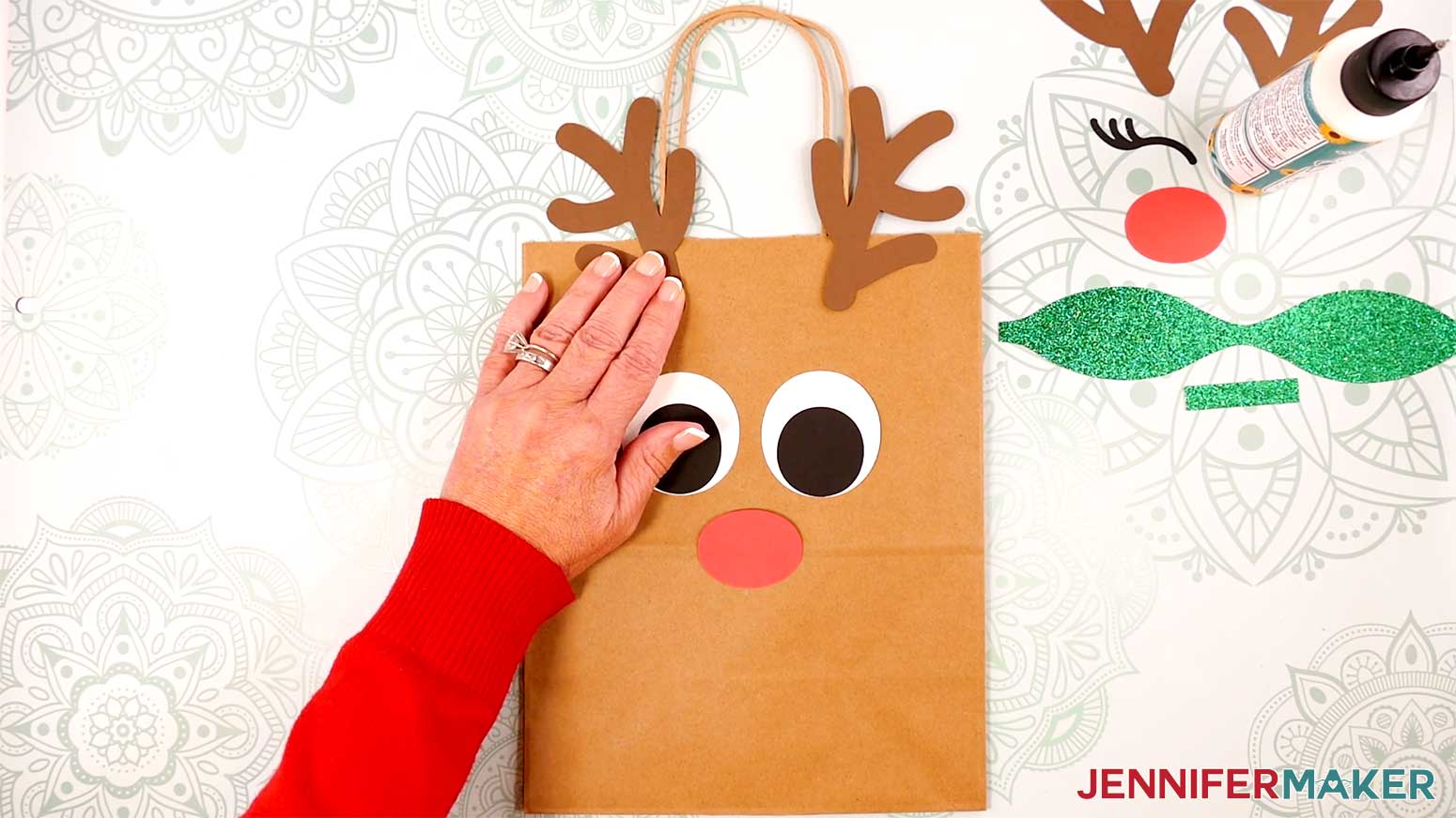 Adhere the Reindeer Gift Bags' antlers above the top edge of the bag in the Cricut Gift Wrapping Ideas project.