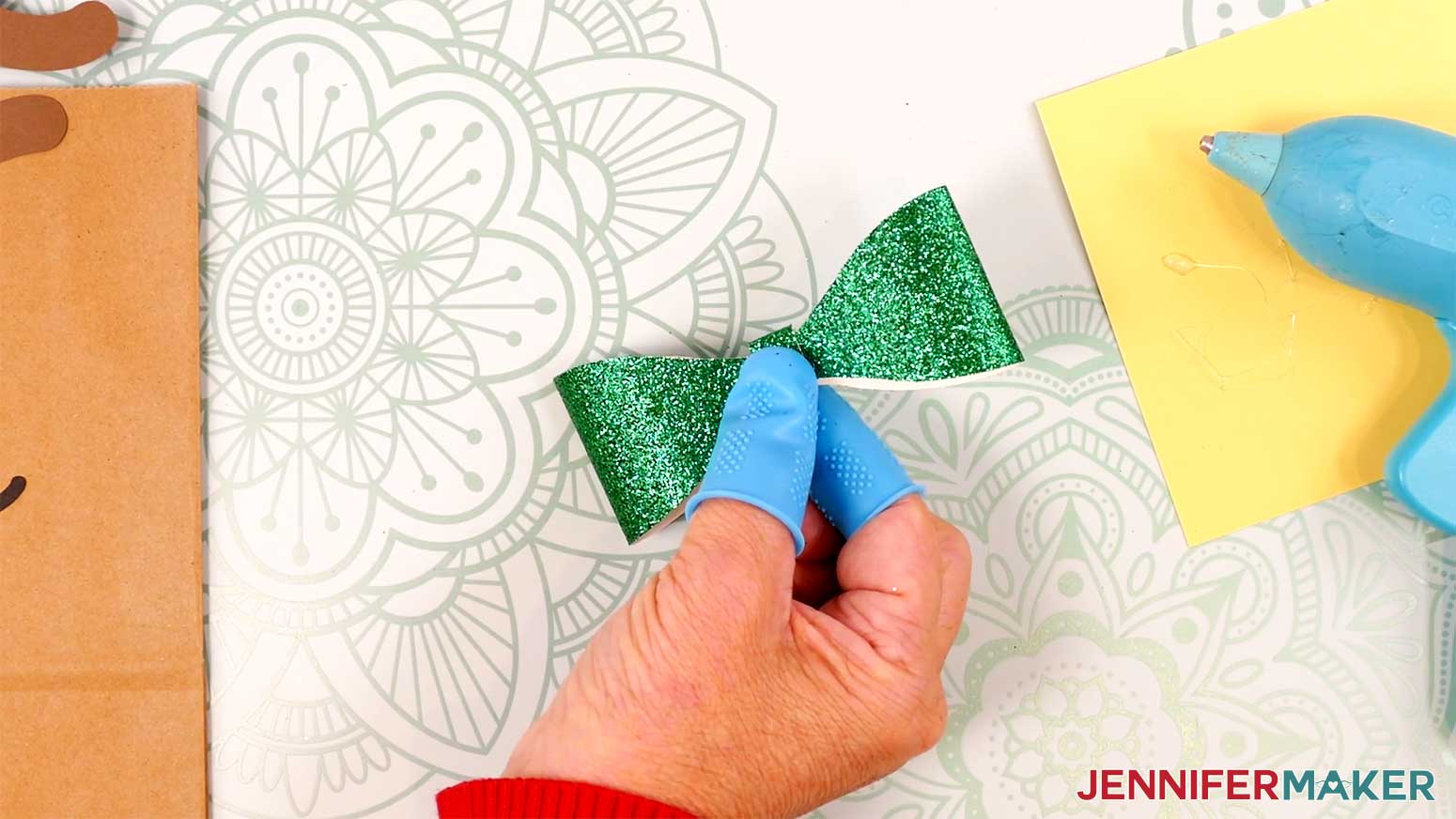 Adhere the strip to the Reindeer Gift Bags' bow in the Cricut Gift Wrapping Ideas project.