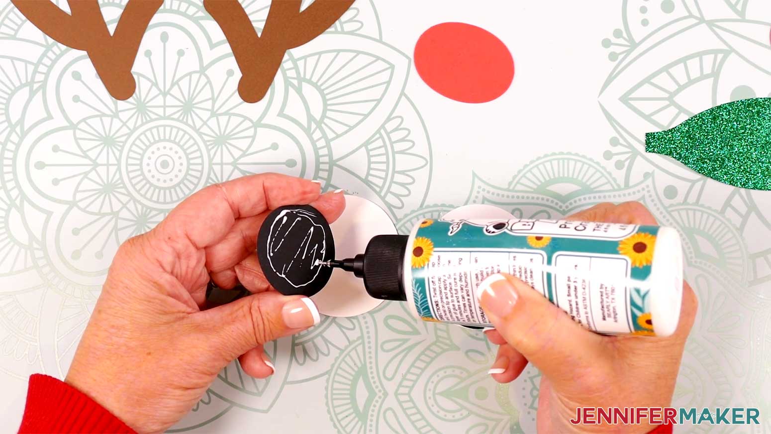 Apply glue to the back of a round black eye piece for the Reindeer Gift Bags in the Cricut Gift Wrapping Ideas project.