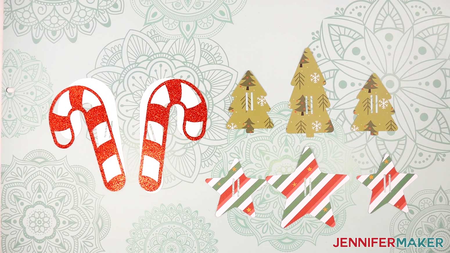 All of the cut slider pieces face up: two red candy cane striped layers, two white candy cane solid layers, two small Christmas trees, one large Christmas tree, and two stars.