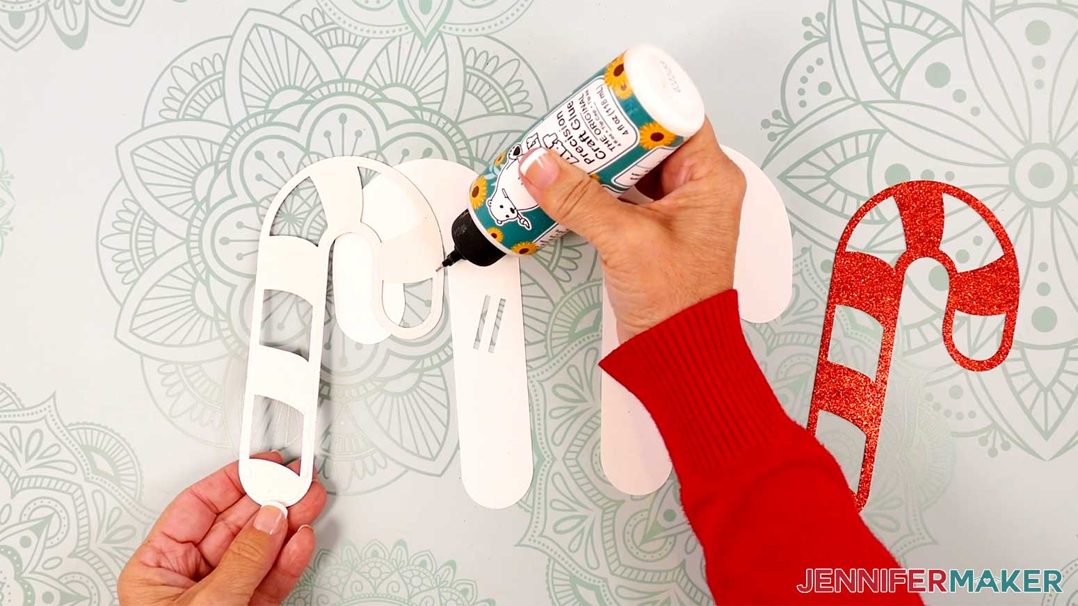 Apply glue to the back of a red candy cane stripe layer.