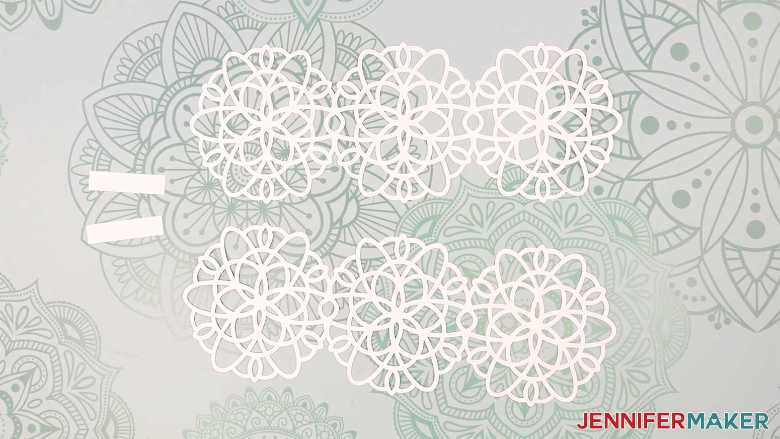 All the snowflake wrap pieces face up: two white rectangular strips and two white snowflake set pieces.
