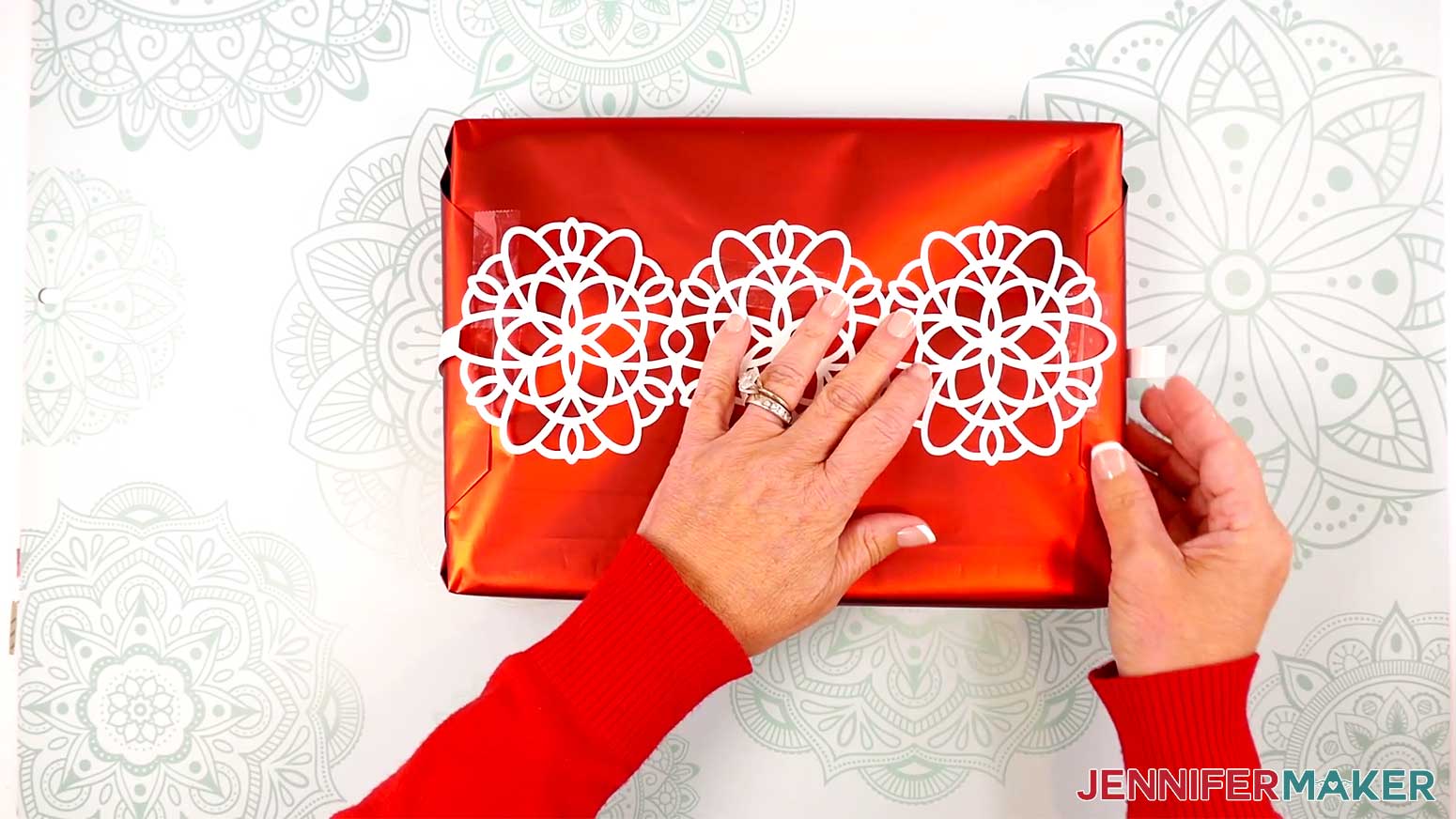 Wrap the rest of the snowflake wrap around the box, creasing the paper around the corners.