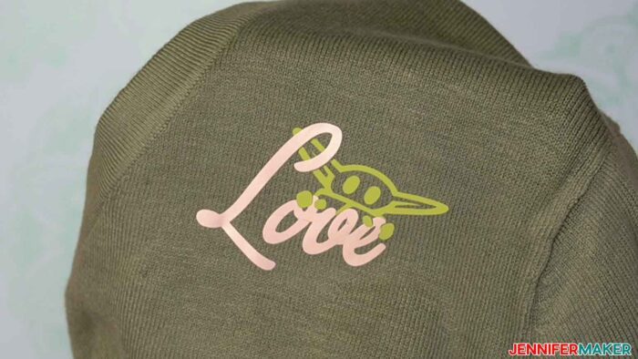 Sage green sweater with avocado green Grogu and gold Love in iron on vinyl