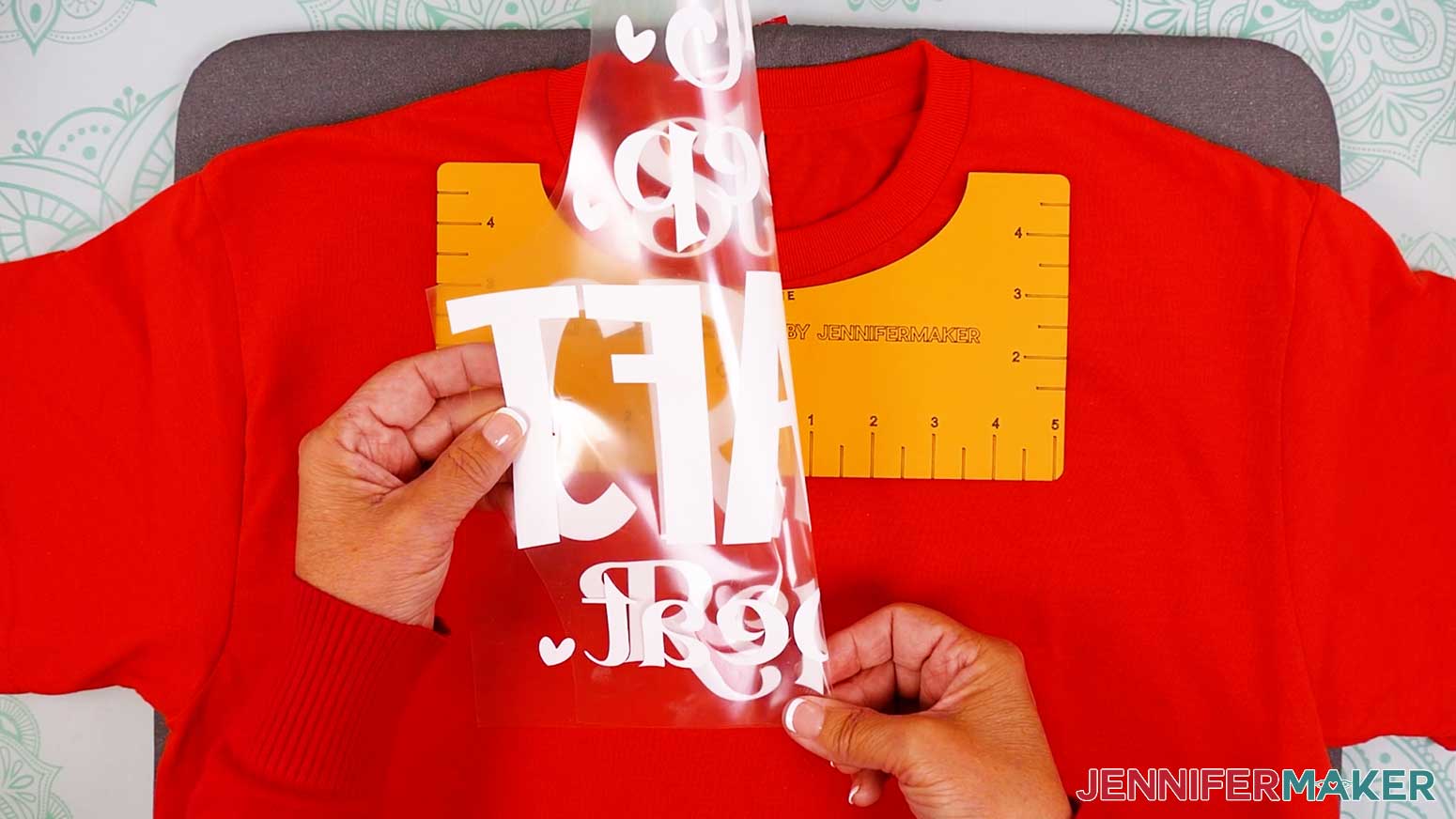 Fold the design in half and press creases into the carrier sheet above and below the Cricut Iron On Vinyl design.