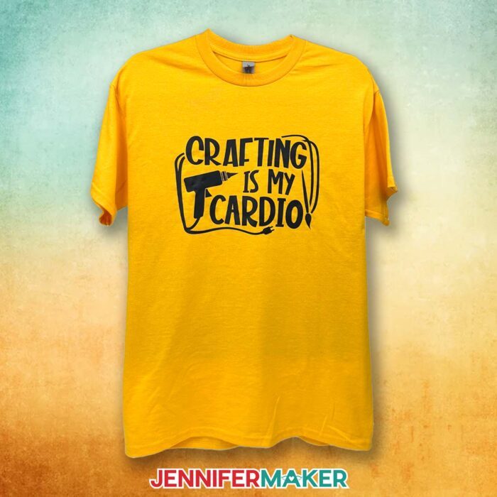 A yellow T-shirt with a black vinyl decal says "Crafting Is My Cardio." Learn how to make T-shirts like these in my Cricut Iron-On Vinyl Tutorial