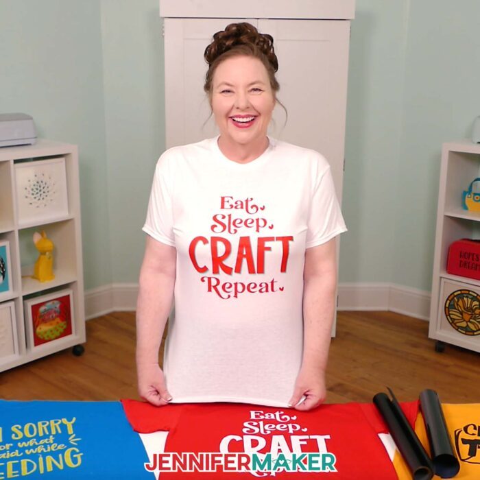 Jennifer Maker shows off a white T-shirt she decorated with iron-on vinyl to say "Eat, Sleep, Craft, Repeat." Learn how to make your own in the Cricut Iron-On Vinyl Tutorial