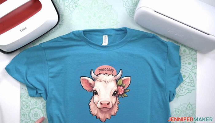 Blue shirt with a pink cow and the word "mooooody" over it made from printable iron on with a Cricut Joy Xtra