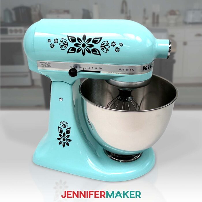 A teal KitchenAid mixer decorated with black floral decals cut with the Cricut Maker 4 & Cricut Explore 4, using the bonus materials right out of the box! 