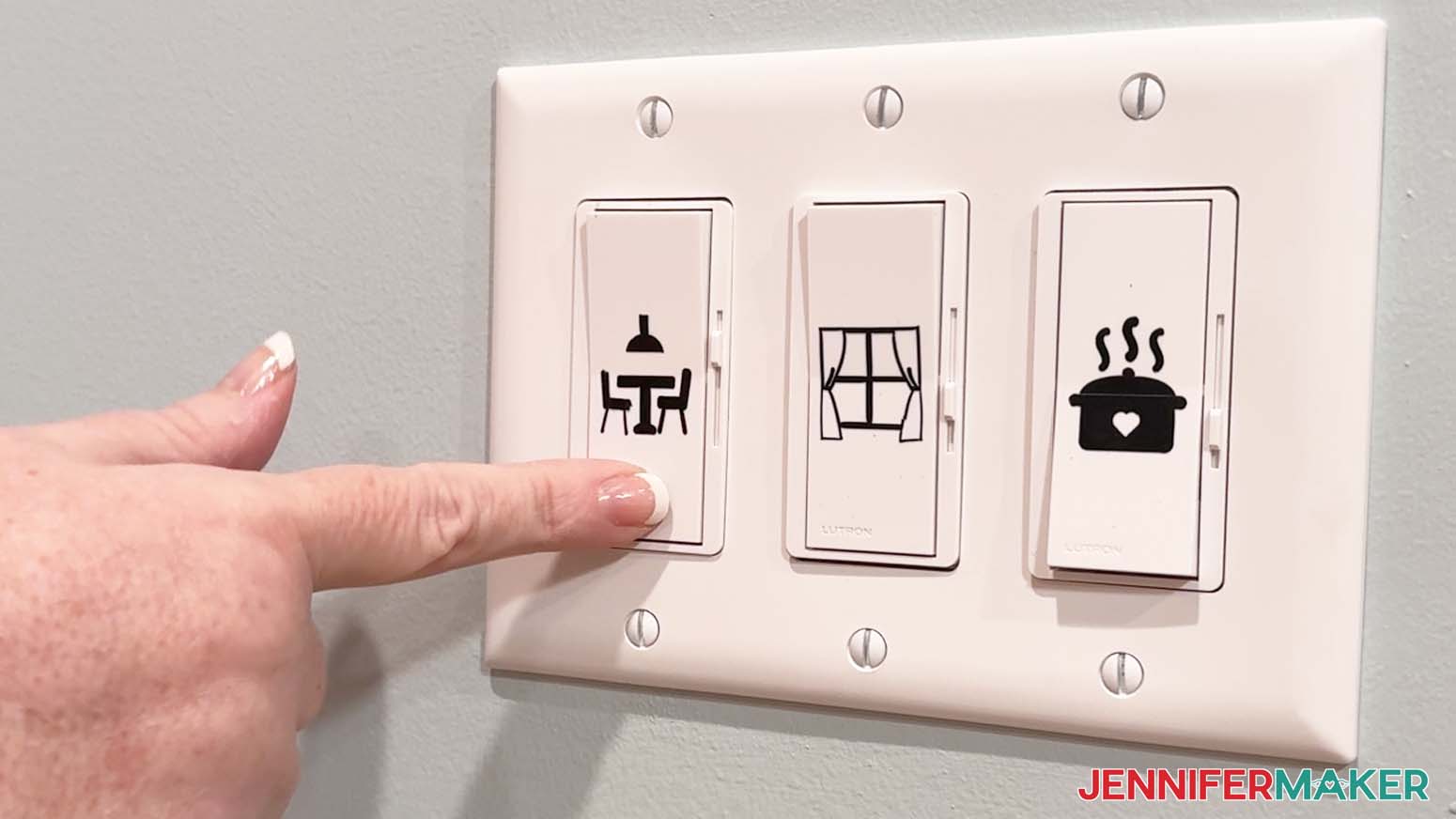 Black adhesive vinyl designs applied to three white light switches.