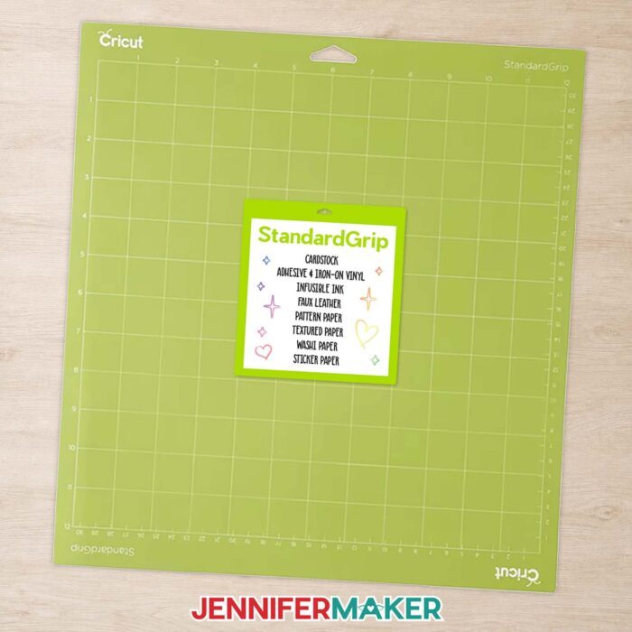 Green StandardGrip Cricut machine mat with a sticker on its cover listing the compatible materials.