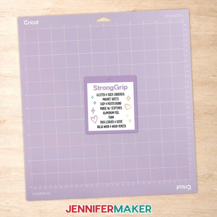 Purple StrongGrip Cricut machine mat with a sticker on its cover listing the compatible materials.