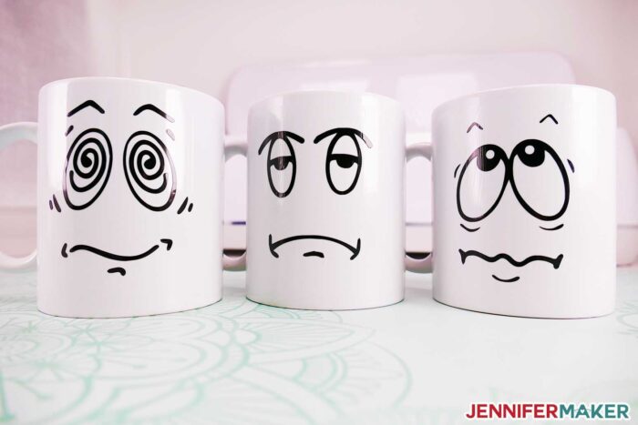 Cricut mugs with funny pre-coffee faces cut in black vinyl and sealed with dishwasher safe mod podge