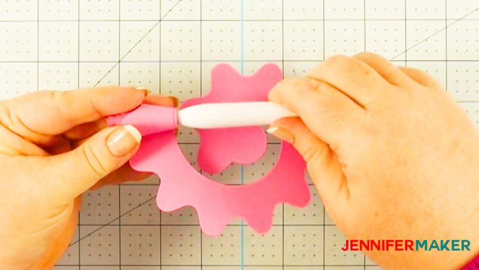 Rolling a cut-out paper pattern around the Cricut quilling tool to make a Cricut paper flower
