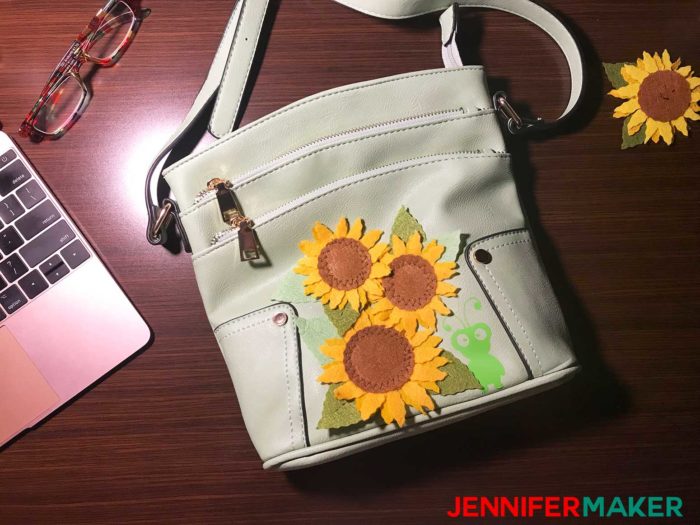 Green purse covered in felt sunflowers and a vinyl Cricut cutie