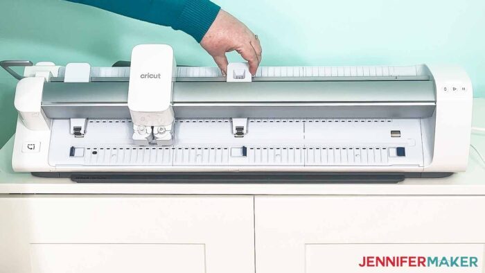 Jennifer Maker moving a pinch roller on a Cricut Venture large format cutting machine.