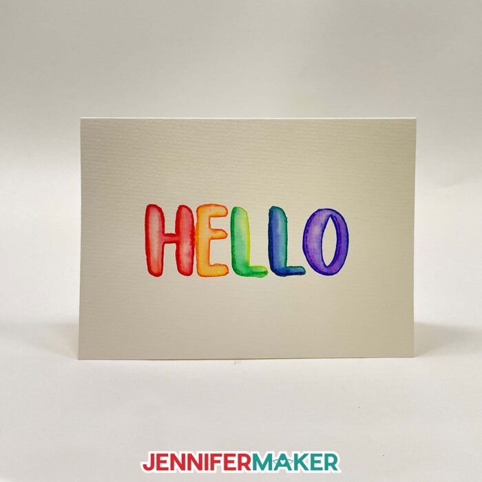 A DIY watercolor card featuring the word painted with Cricut watercolor markers.