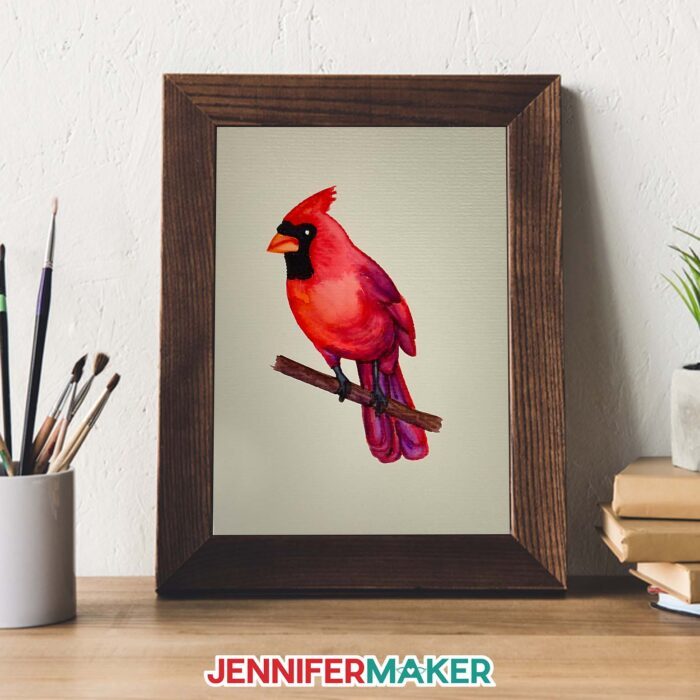 A framed DIY watercolor card featuring a cardinal made with Cricut watercolor markers.