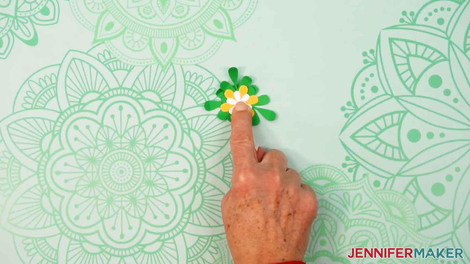 Add the smaller white flower on top of the larger yellow flower and glue it in place.