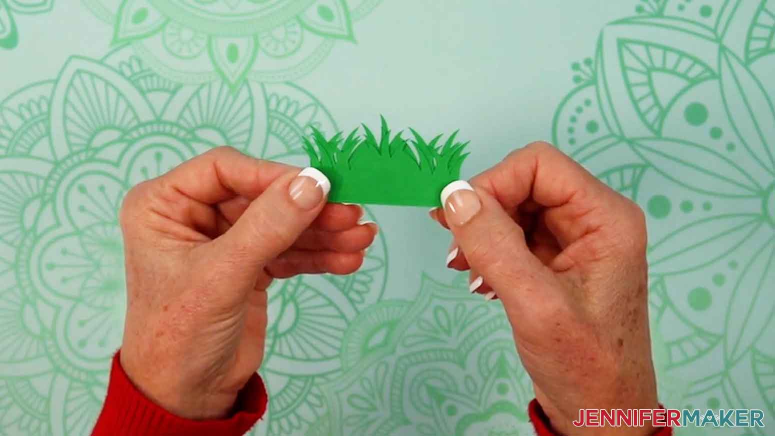 Hold the three longer grass pieces together to identify the taller piece that will be placed on the back panel.