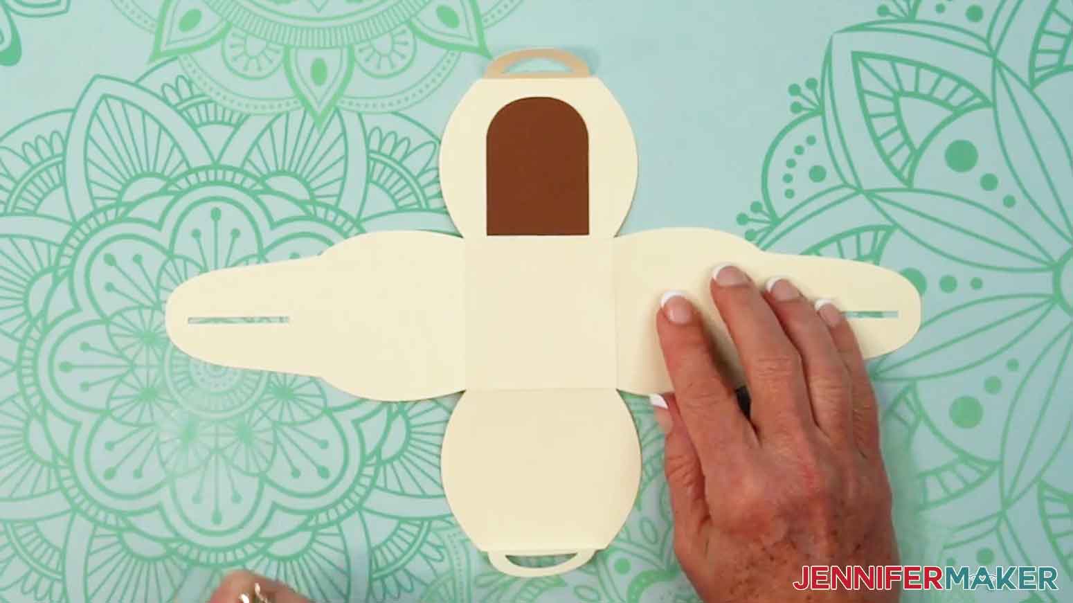 Use craft glue to adhere the solid dark brown door piece to the front panel of the curvy box.