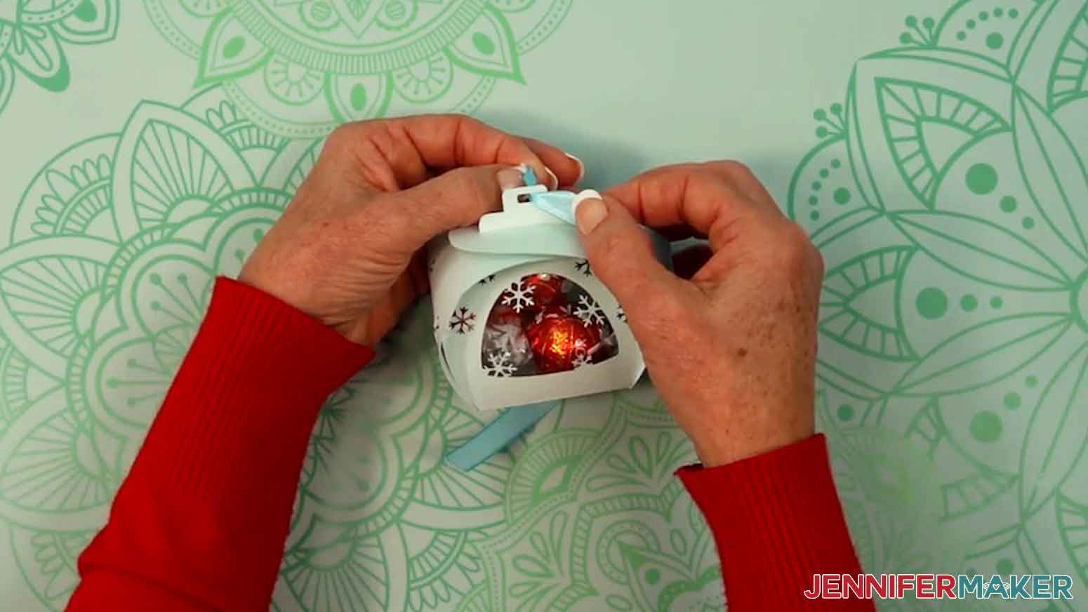 Insert a piece of ribbon through the top whole of the handles.