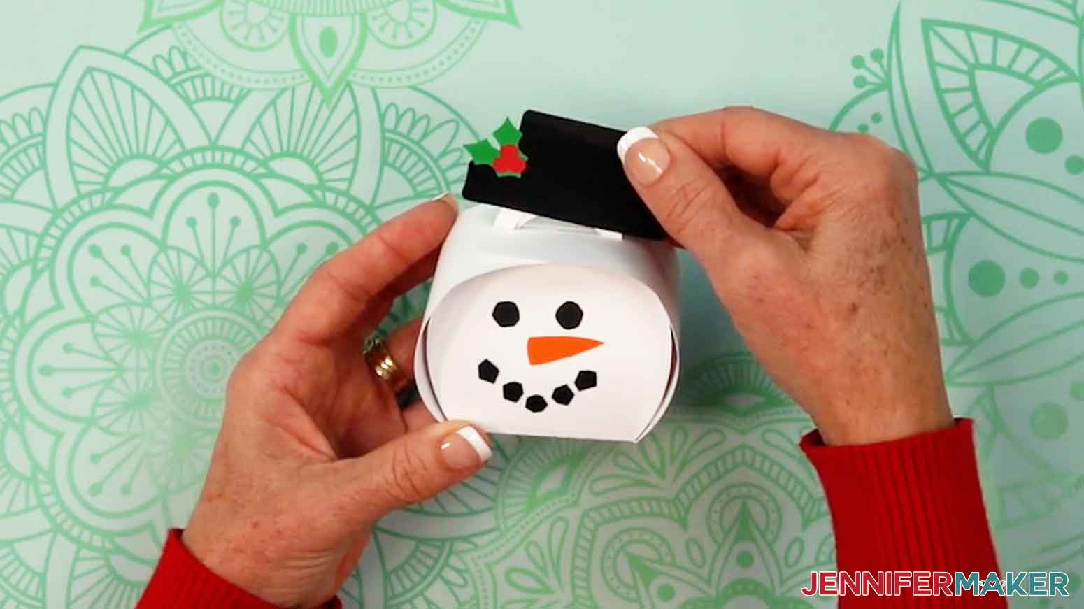 Place the snowman hat on the curvy box handles.