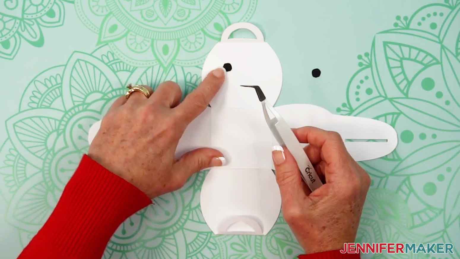 Place and glue the two eye pieces on the front panel of the snowman box.
