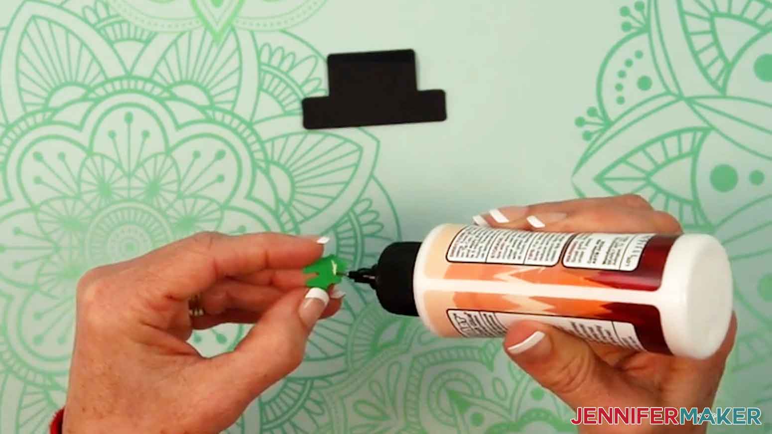 Add a small dot of glue to the back of the holly leaf.