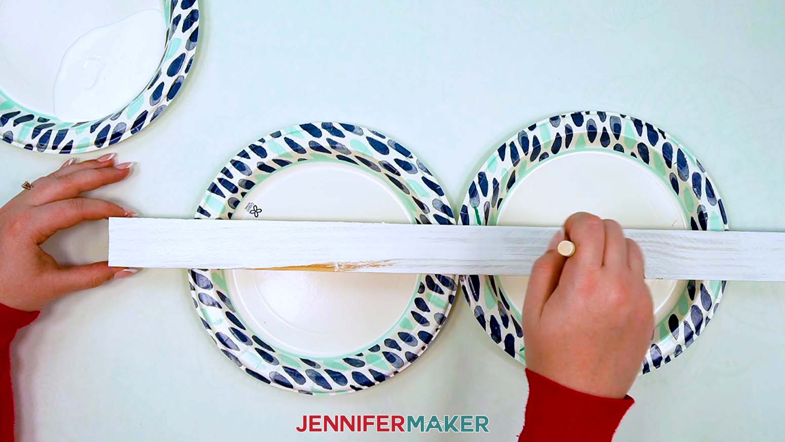 Apply white paint to the wooden yard stake with a foam paint brush.